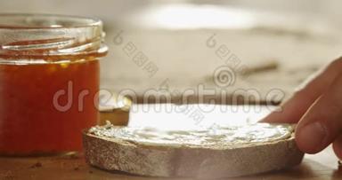 红色鱼子酱在厨房的木桌上用银色勺子撒在一片黑面包上，红色史诗上用太阳花拍摄
